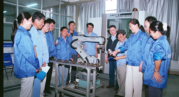 2007年，无锡职业技术大学数控技术教学团队‌入选国家级教学团队，该团队正在探讨机器人与数控机床的系统连接。受访者供图
