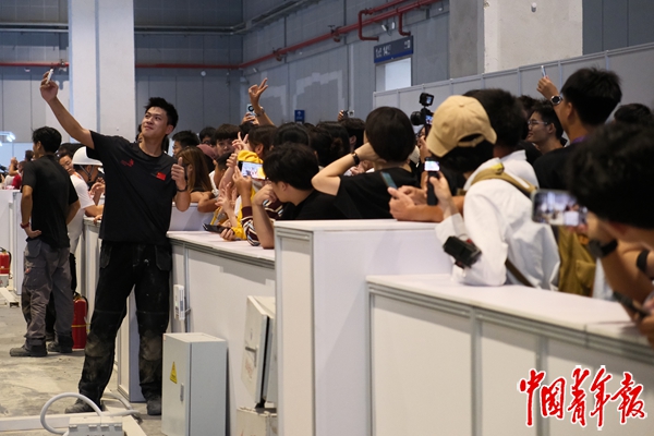 9月26日，上海，第48届世界技能大赛，在“混凝土建筑”比赛现场，中国队员姚王泽（左二）在比赛结束后与在场观众自拍留念。中青报·中青网记者 田嘉硕/摄