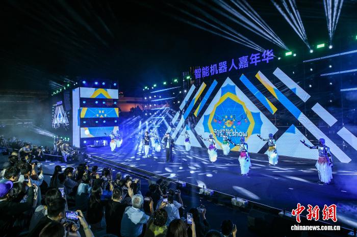 5月28日晚，一场充满科技感与趣味性的“智能机器人嘉年华”亮相天津文化中心，作为2026世界智能产业博览会的亮点活动之一，嘉年华以“慧聚河西，智能无限”为主题，设置了机器人场景展、机器人挑战赛、机器人舞台秀、智能消费市集等多个特色展区，让市民在城市公共空间沉浸式感受前沿智能科技。图为民众观看机器人文艺表演。　记者 佟郁 摄