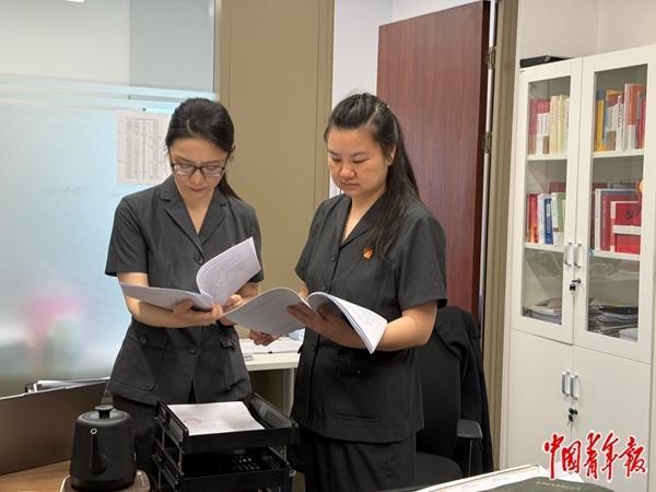 北京金融法院法官舒翔（左）与同事讨论案情。中青报·中青网记者 刘胤衡/摄