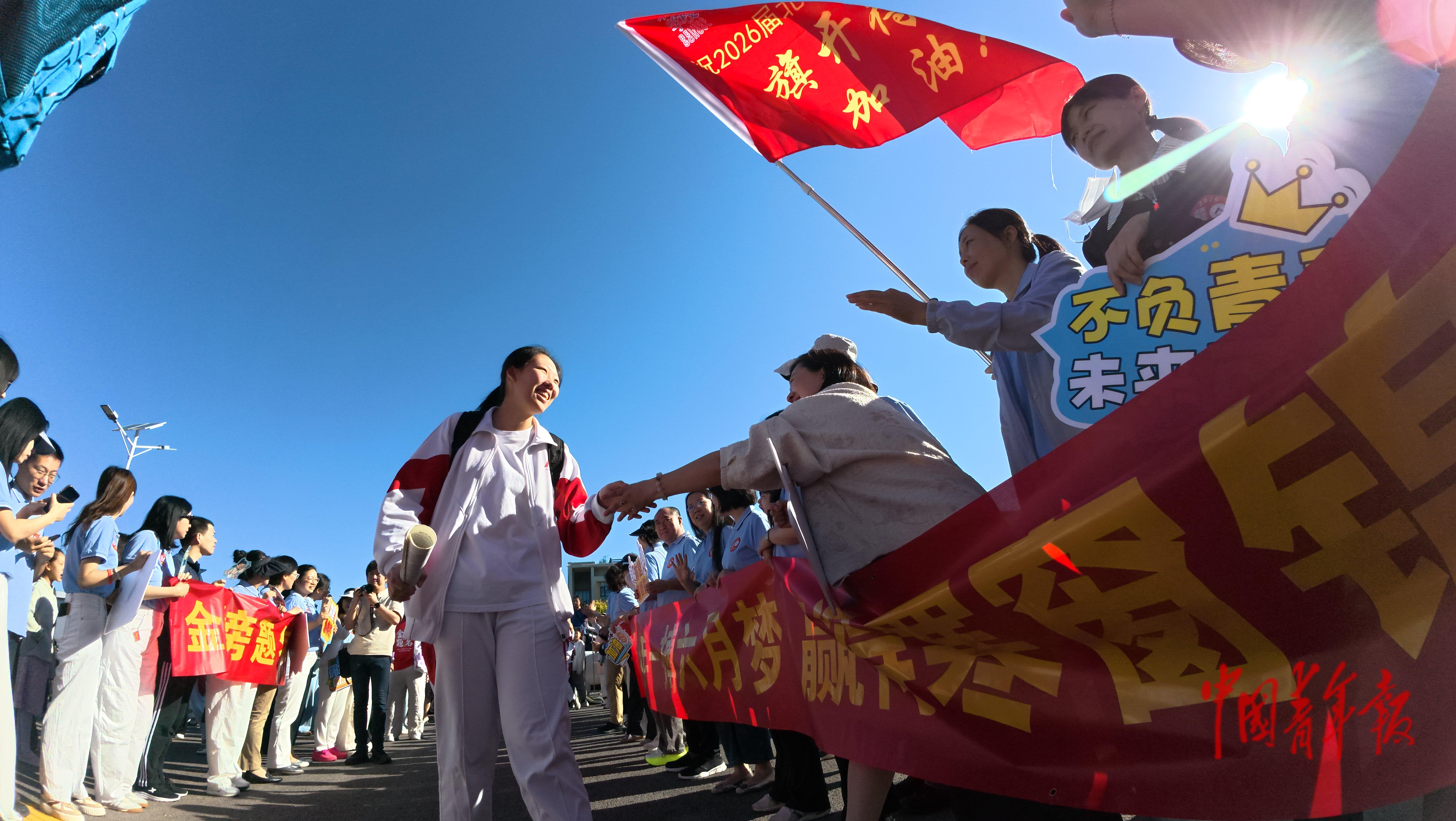 6月7日，北京通州，人大附中通州校区，高考班的教师们在考点外为学生加油鼓劲。当日，2026年高考正式开考，全国将有1290万人奔赴考场。中青报·中青网记者 陈思阳/摄