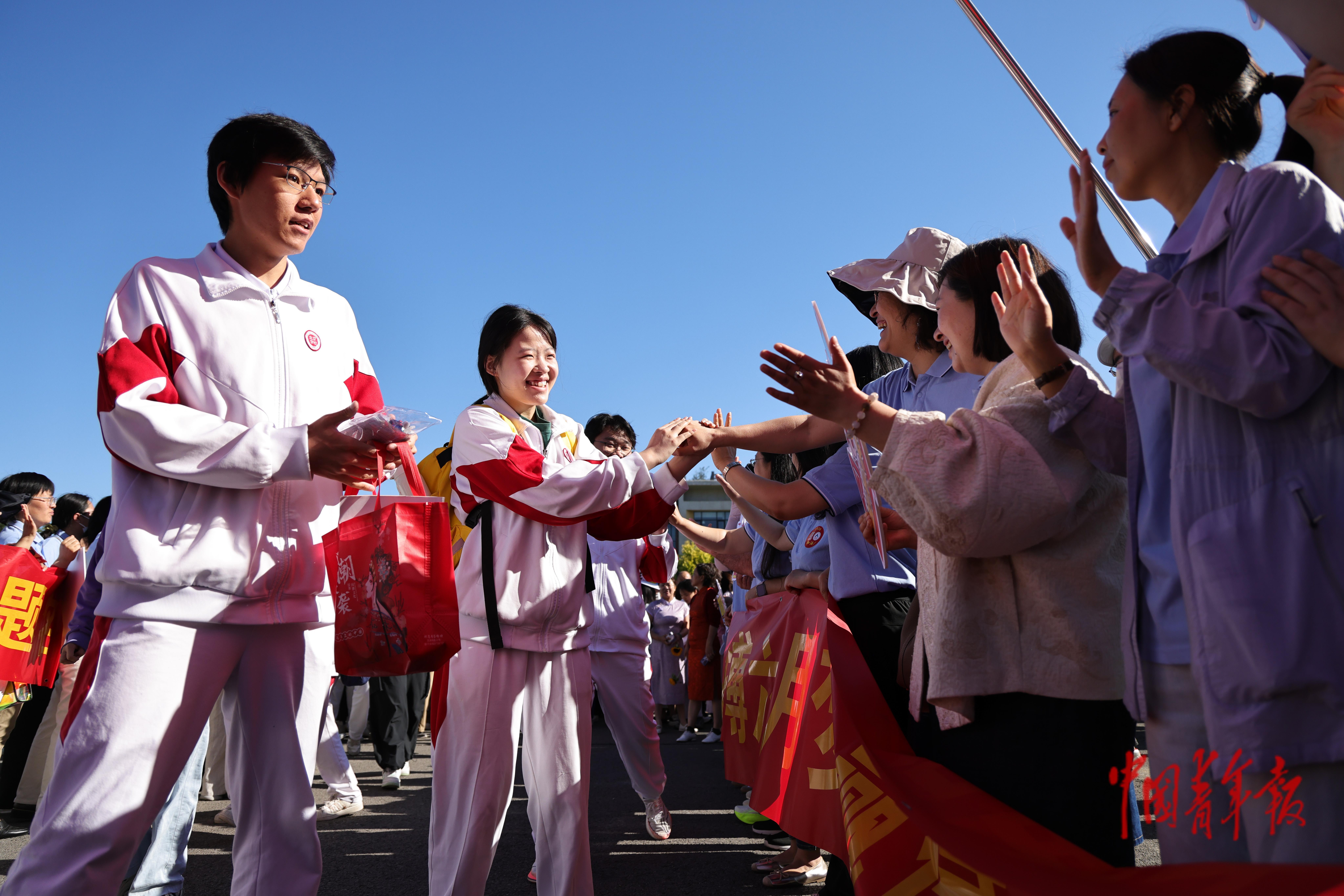 6月7日，北京通州，人大附中通州校区，高考班的教师们在考点外为学生加油鼓劲。2026年北京市普通高等学校招生考试包括统一高考和普通高中学业水平等级性考试。其中，统一高考科目为语文、数学、外语3门，考试时间为6月7日至8日；学考等级考科目为思想政治、历史、地理、物理、化学、生物6门，由考生自主选择3门参加考试，考试时间为6月9日至10日。中青报·中青网记者 陈思阳/摄