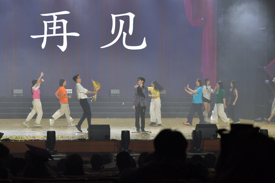6月10日，北京，中国传媒大学1500人报告厅，新闻学院“炫夏离歌”毕业晚会上，同学们在表演节目，背板显示屏上打出“再见”二字。李家瑞/摄