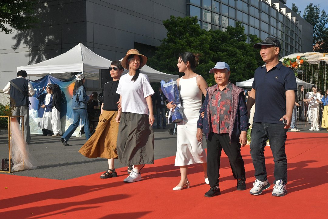 6月10日，北京，中国传媒大学，新闻学院毕业生与家人一同走过毕业红毯。李家瑞/摄