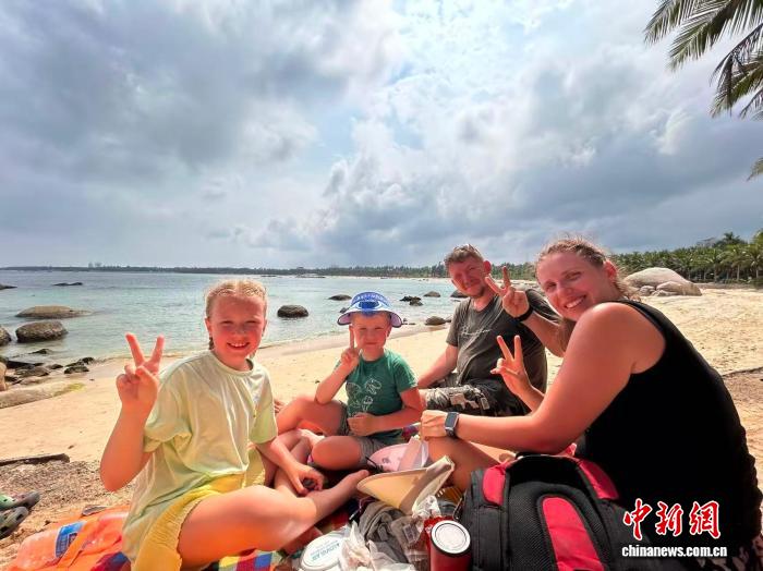 6月11日，俄罗斯游客塔蒂亚娜一家四口在文昌淇水湾沙滩观看火箭发射后合影留念。 中新网记者 符宇群 摄