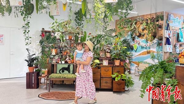 5月29日，在丽雅社区，一位家长带着孩子刚逛完花店。中青报·中青网记者 赵丽梅/摄