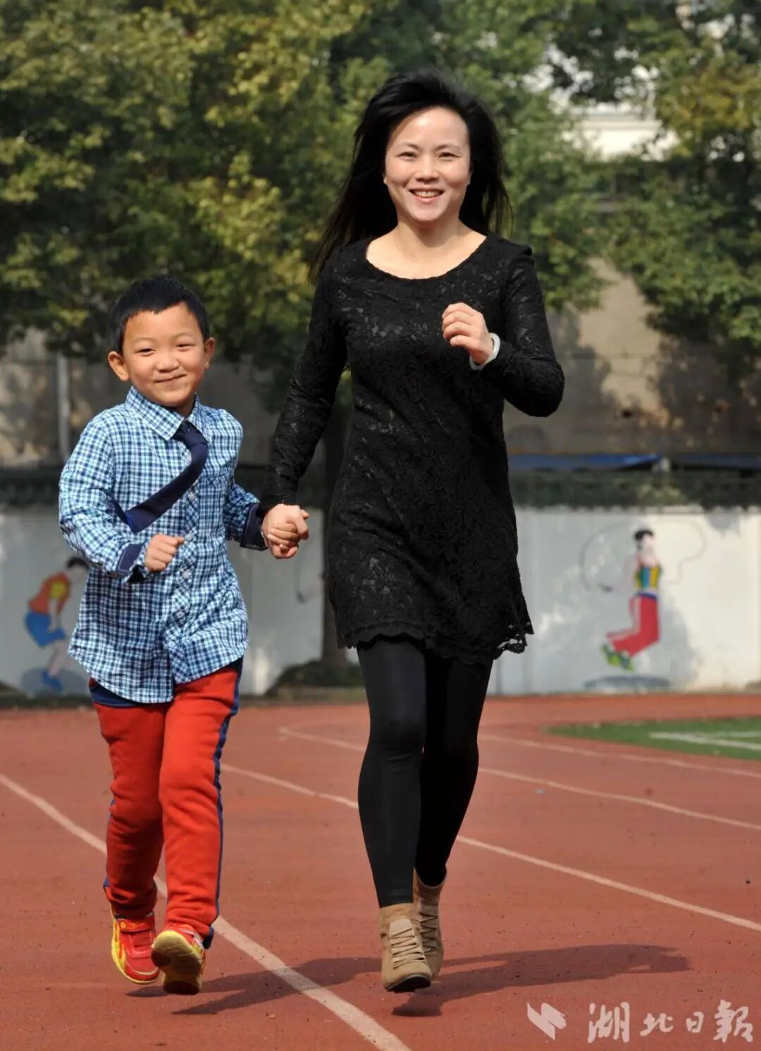 郭斌入校后，张龙老师带着他在学校操场锻炼身体。