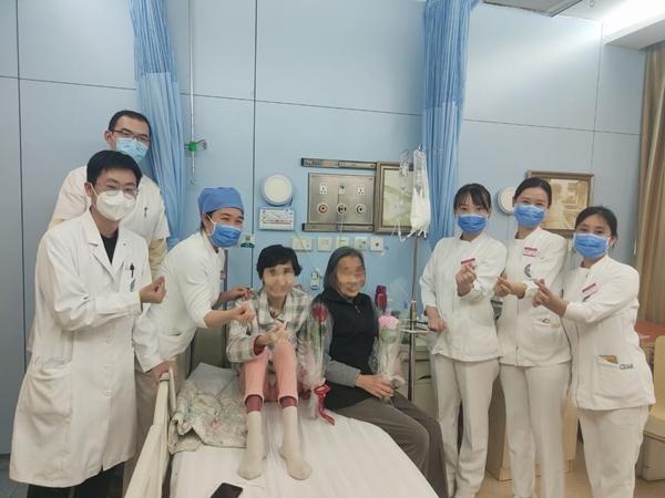 戚政烨（左一）与安宁疗护病房的工作人员、林巧舒（左四）合影，林母（右四）坐在林巧舒身旁。受访者供图