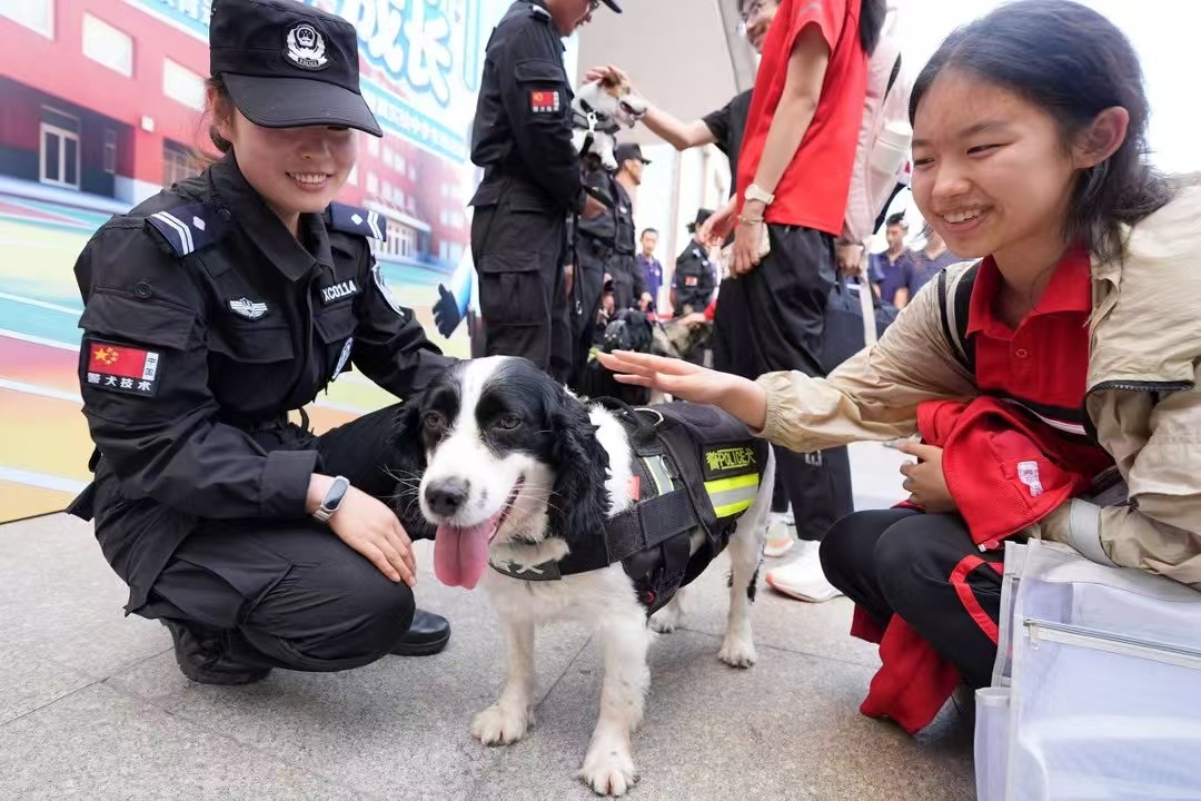 警犬训导员携工作警犬走近师生中间。北京警方/供图