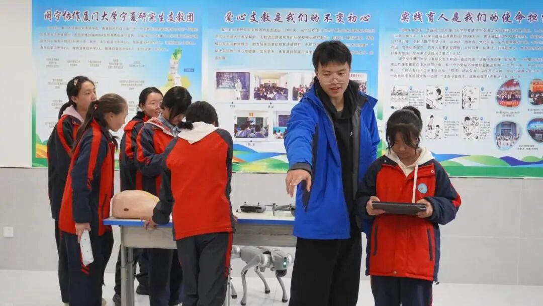 2025年10月,宁夏固原市隆德县第二中学凤凰花科创室,厦门大学第27届研究生支教团隆德分队队员陈炫指导学生操作科技设备。厦门大学研究生支教团供图