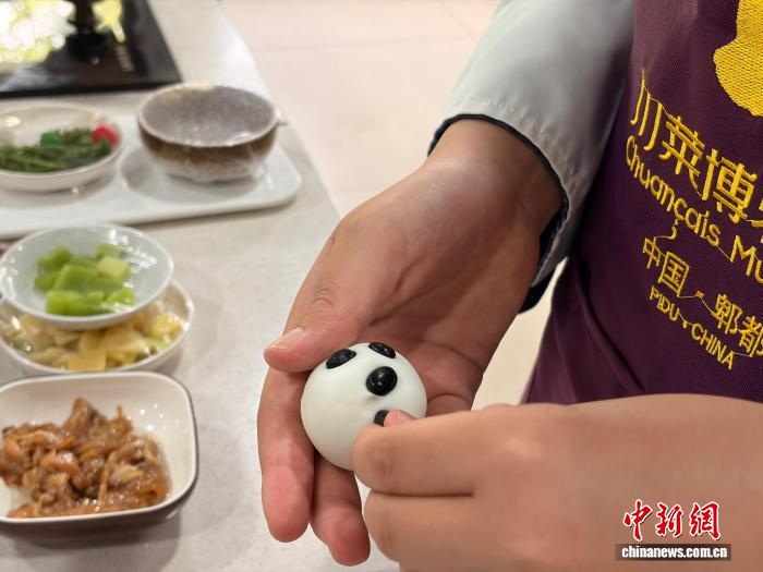 7月9日，四川成都，第三期美国华裔青少年“巴蜀文化品悟之旅”营员学做大熊猫汤圆。王利文 摄
