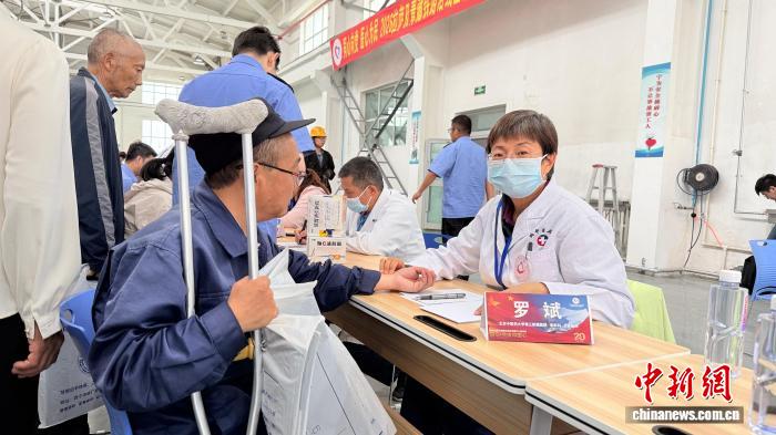 7月10日，参加2026年“同心·共铸中国心”西藏拉萨、青藏铁路沿线公益活动的部分医疗专家来到格尔木机务段，开展医疗公益活动。图为来自北京的医疗专家罗斌在为铁路一线职工和沿线群众义诊。受访者供图
