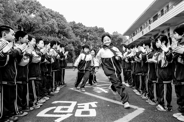 湖南省永州市新田县洞心中心小学，同学们穿着新校服在运动场上快乐游戏。刘贵雄摄/光明图片