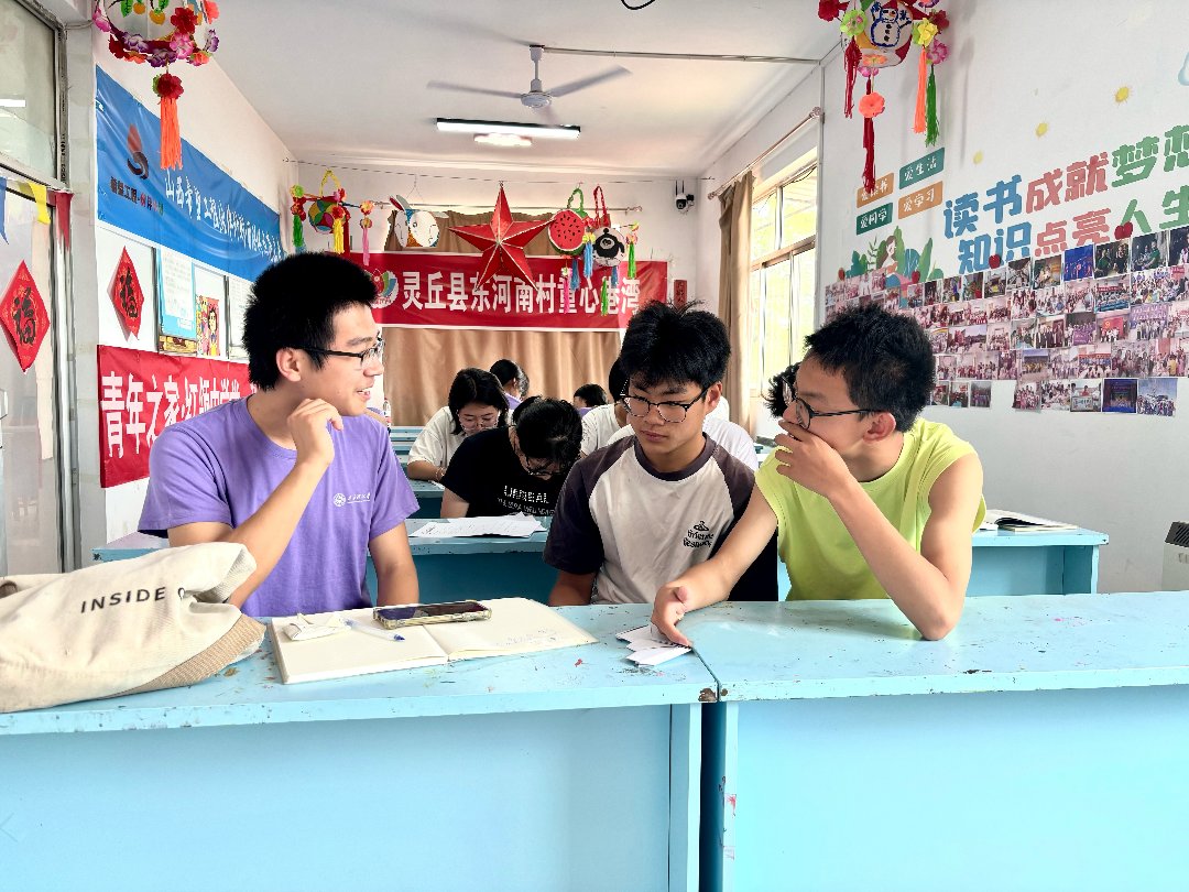 太原理工大学“三下乡”社会实践队队员为托管班学生答疑解惑。姚佳美供图