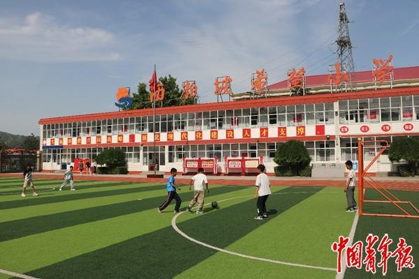 西柏坡希望小学，在足球场上踢球的少年。