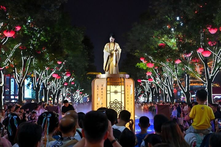西安大唐不夜城的演员“李白”与游客对诗互动（2024年7月9日摄）。新华社记者 邹竞一 摄