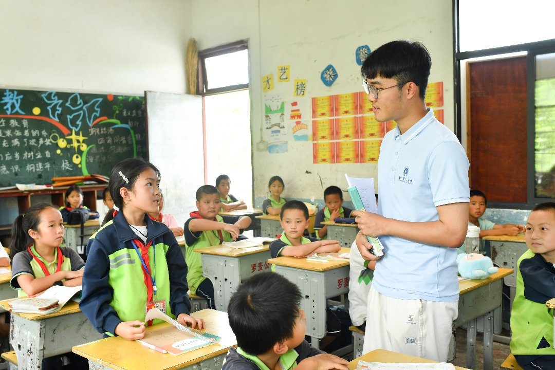 7月6日，贵州省黄平县上塘镇中心小学，徐州医科大学研究生支教团成员袁子坤给三年级学生复习。 梁文/摄