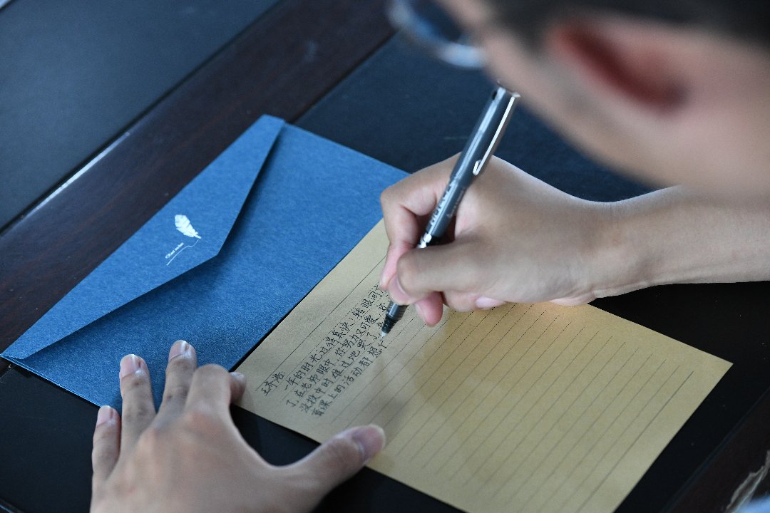 7月10日，贵州省黄平县上塘镇中心小学，徐州医科大学研究生支教团成员袁子坤给全校学生写了121封信和65张贺卡。梁文/摄