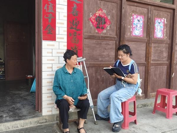 贵州省毕节市织金县六花村，马云坐在苗语发音人身旁，边听边记。受访者供图