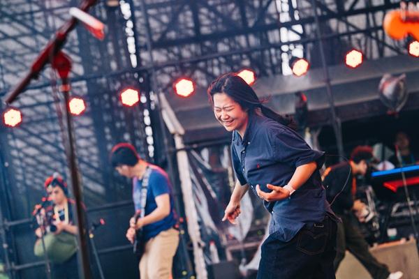 6月14日，江苏新沂，在河流音乐节的演出舞台上，李沛颖正用手语翻译刺猬乐队的歌曲。本文图片均由受访者提供