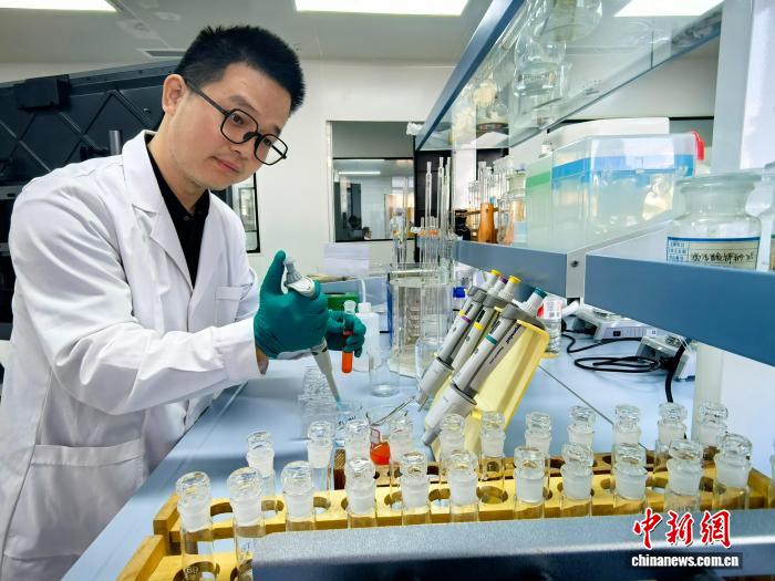 图为重庆市生态环境科学研究院工程师余义昌在实验室对收集到的水质进行测试。重庆市生态环境局供图