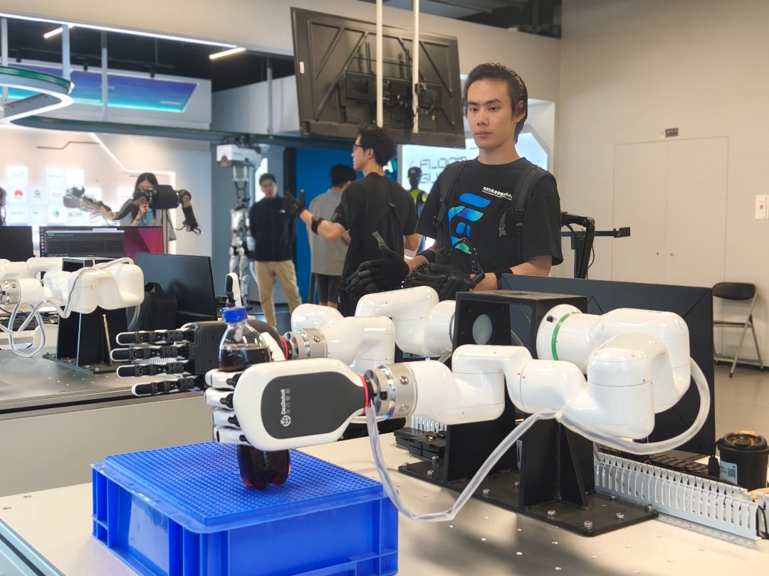 7月29日，杭州市具身智能展示与应用推广中心二楼，一家企业的工程师正在训练机器手臂精准抓握一瓶可乐。中青报·中青网记者 宁迪/摄