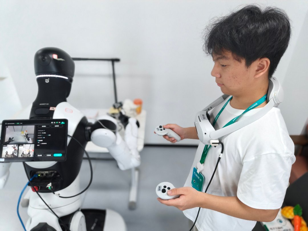 7月30日,浙江清华柔性电子技术研究院具身智能实训场里,作为数据采集员,朱思凯身上要佩戴专业的VR眼镜,手持机械爪来同步控制机器人的上肢动作。中青报·中青网记者 宁迪/摄