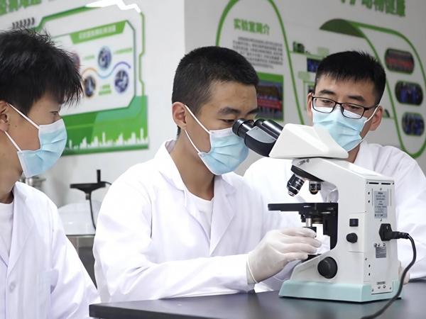 战利（右一）指导学生分析病理。长春职业技术大学供图