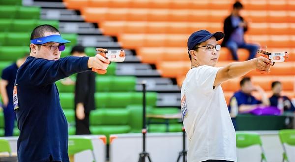 　　张岳华（右）参加2025年上海城市业余联赛上海市光感射击公开赛。受访者供图