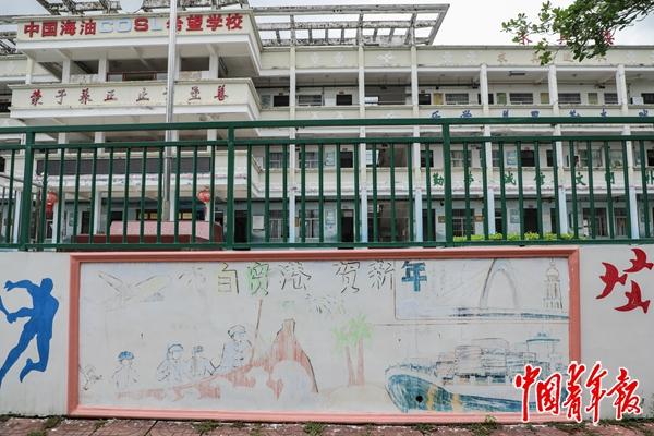 　　7月8日，陵水县隆广镇丹录村中国海油COSL希望小学，一面由学生绘制的文化墙。这幅作品描绘了从海南解放到自贸港建设的历史跨越。今年年初，各班利用中海油捐赠的颜料，自主查找资料、自行创作完成新年文化墙。墙画经历了大半年的日晒雨淋，虽然画面已有些模糊，但孩子们对家乡未来的憧憬并未褪色。