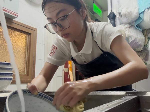 “生存训练”实践团成员李宇欣在后厨洗碗。浙江师范大学供图