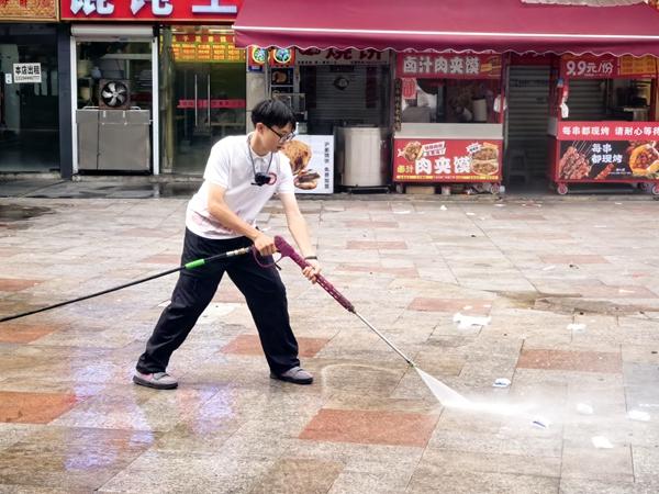 　　“生存训练”实践团成员程润健从事地面清扫工作。浙江师范大学供图