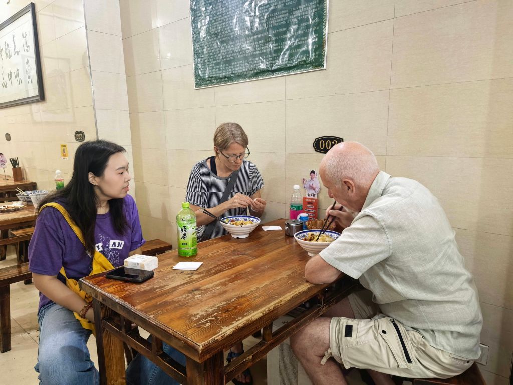 8月1日，外国游客在回民街品尝美食。新华社记者 蔡馨逸 摄