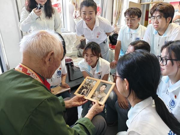 晋中信息学院远景学院“青雁归巢·智赋北洸”乡村振兴促进团走进山西省晋中市太谷区北洸乡，团队依托“AI忆时光”项目为95岁抗美援朝老兵杨致让修复了泛黄破损的军装老照片，并在现场聆听红色故事。晋中信息学院供图