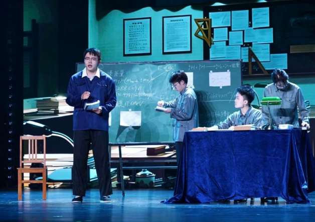 2026年4月，国科大在雁栖湖校区学生礼堂举办第三届弘扬“两弹一星”精神话剧大赛。图为徐靖坤（左一）演绎于敏推算理论。国科大供图