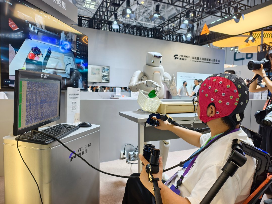 8月19日，北京经济技术开发区，2026世界机器人大会世界机器人博览会展区内，观众正在通过脑机与具身数据引擎设备来控制机器人抓取水果蔬菜模型。中青报·中青网记者 尹希宁/摄