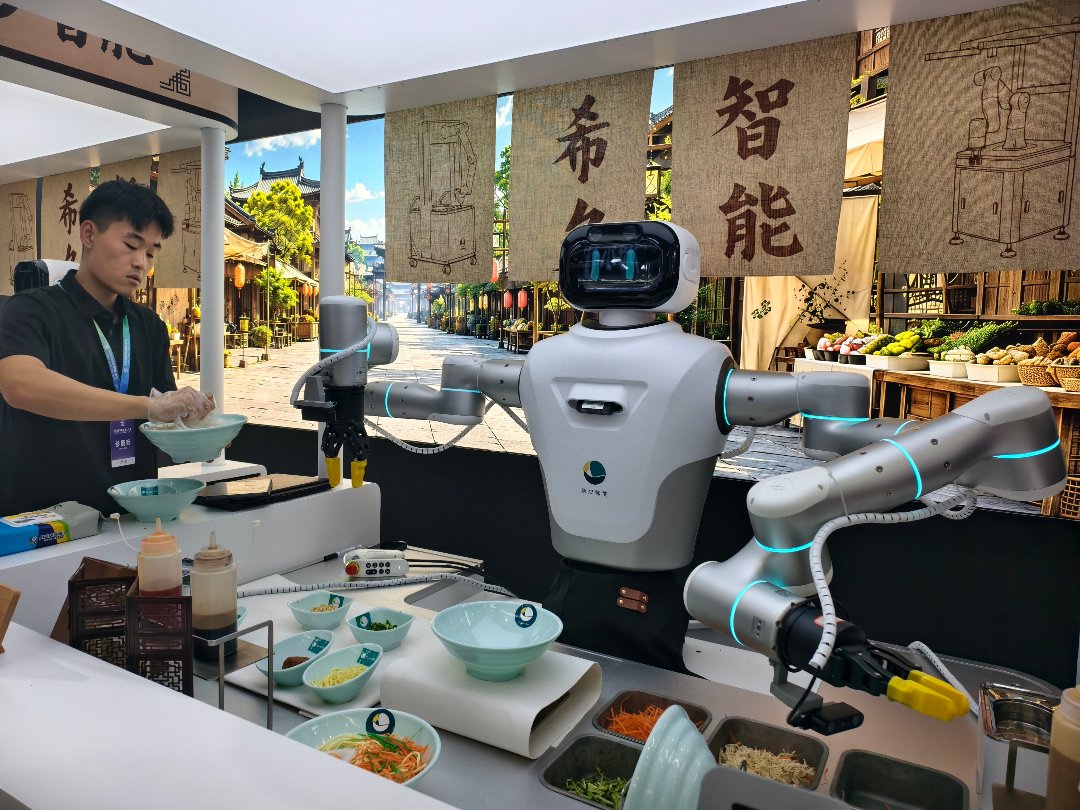 8月19日，北京经济技术开发区，2026世界机器人大会世界机器人博览会展区内，一款机器正在煮面。与往年相比，本届世界机器人博览会展区除了展示机器人舞蹈、跑跳等动作外，与人类生产生活息息相关的应用场景也“搬”进了展区。中青报·中青网记者 尹希宁/摄