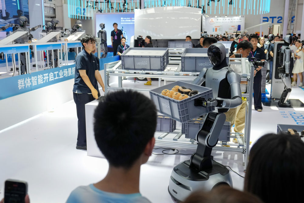 2025年8月11日，在世界机器人大会展馆内，观众在优必选公司展台观看人形机器人从入库搬运到智能分拣的全流程作业展示。新华社记者 鞠焕宗 摄