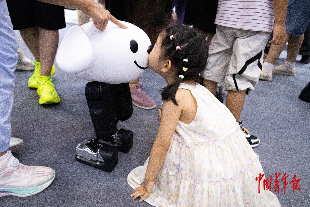 8月22日，北京北人亦创国际会展中心，2026世界机器人大会现场，小观众与京东小机器人进行互动。张旭冉/摄
