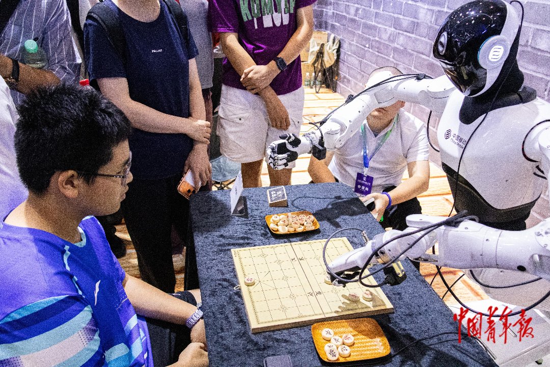 8月22日，北京北人亦创国际会展中心，2026世界机器人大会现场，小观众同中国移动智能机器人展开象棋对弈。张旭冉/摄