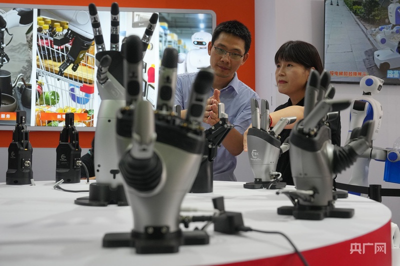 2026年8月19日，北京，观众在北人亦创国际会展中心举办的世界机器人大会上观看展出的机器人手。