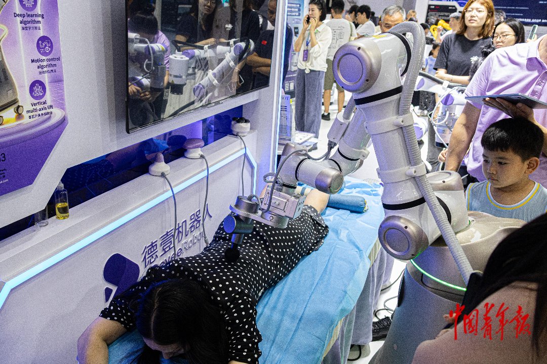 8月22日，北京北人亦创国际会展中心，2026世界机器人大会现场，观众体验机器人按摩服务，切身感受智能科技。张旭冉/摄