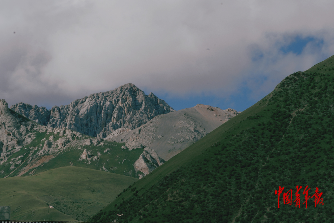 杂多县背后的布涌山峰层峦叠嶂，一颗颗绿色植被为山坡点缀了更深的色彩，与远处山巅形成鲜明比对。北京印刷学院 张一骢/摄
