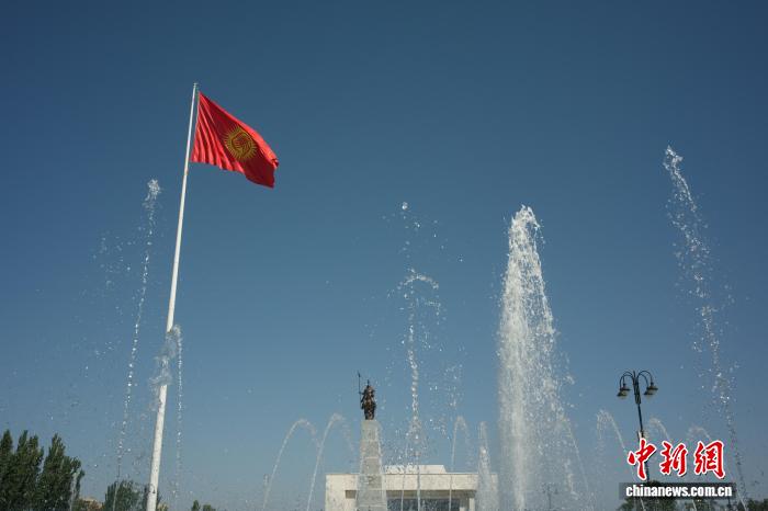 近日，在吉尔吉斯斯坦首都比什凯克阿拉套广场拍摄的吉尔吉斯斯坦国旗和玛纳斯雕像。中新社记者 盛佳鹏 摄