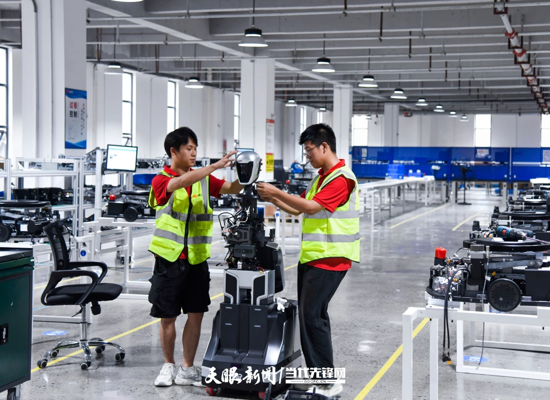 贵安新区威迈尔科技有限公司的生产车间，工人协同作业，装配智能机器人。杨涛 摄