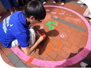 孩子们在实践队员指导下，描画地绘作品。西安交通大学/供图