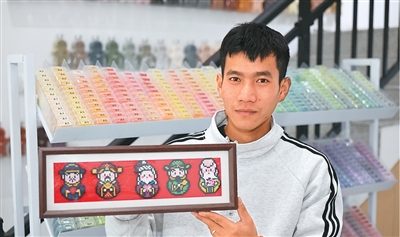 江苏省淮安市一家手工创意工坊内，消费者正在展示拼豆作品。殷潮摄（人民图片）