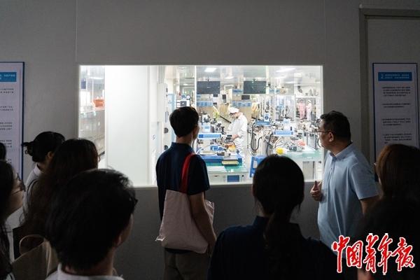 8月5日，江西安远，在江西微电新能源有限公司的微型锂电池生产一线，调研队师生正在与企业负责人交流。中青报·中青网记者 陈宇龙/摄