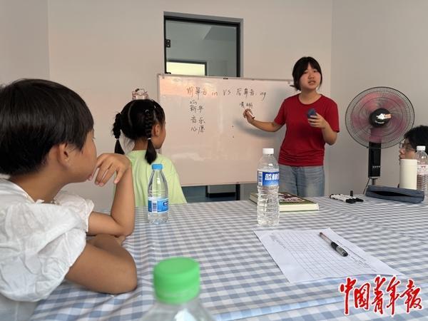 7月28日，在内蒙古通辽市甘旗卡镇团结社区，中国人民大学支教团成员为暑托班孩子辅导发音。中青报·中青网记者 石佳/摄
