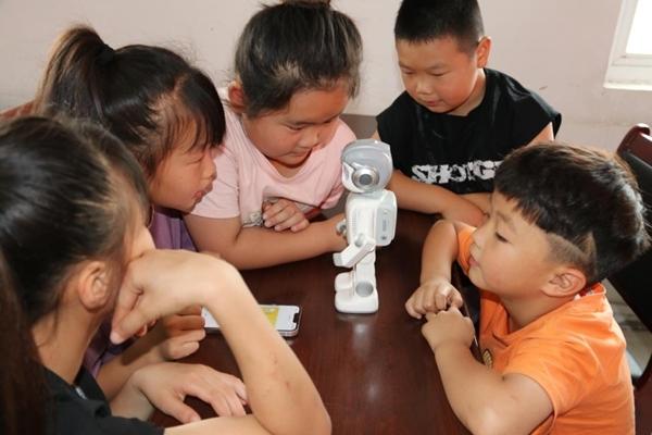 　　阜阳师范大学计算机与信息工程学院在阜阳市插花镇开设“青耕学堂”，图为孩子们在上机器人课程。受访者供图